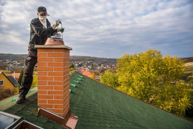 Masked technician working on a brick chimney top in Matthews, NC. Home Fire Safety Services Near Me.