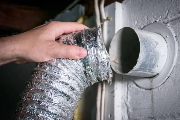 Hand connecting a foil dryer duct to a wall vent, dryer vent replacement in Charlotte, NC by Smoke Alert