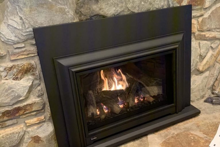 Gas fireplace insert with bright flames in a stone surround, home fire safety services in Charlotte, NC by Smoke Alert